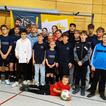 Eine Fußballmannschaft mit Fußball in einer Turnhalle